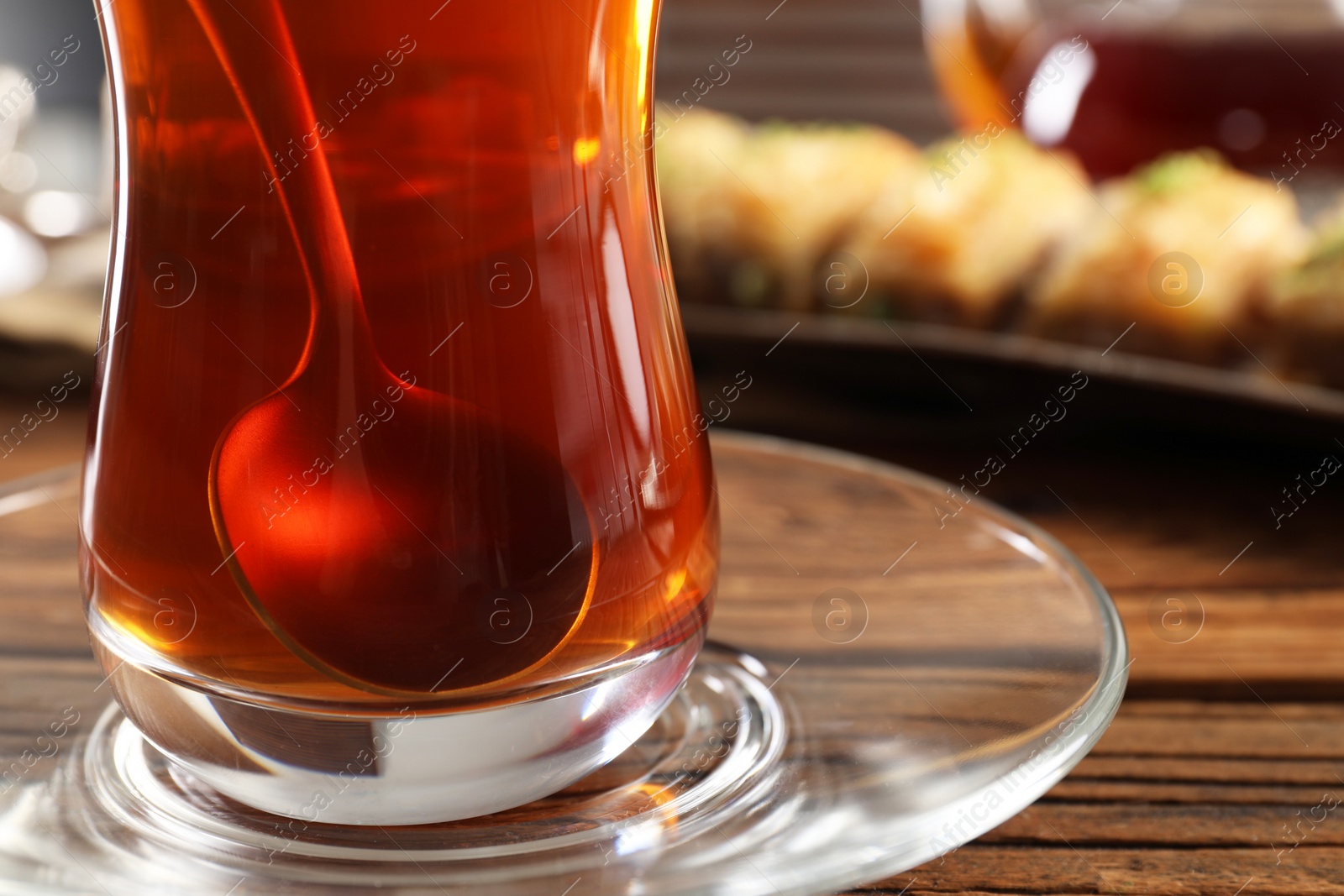 Photo of Traditional Turkish tea in glass on wooden table, closeup. Space for text