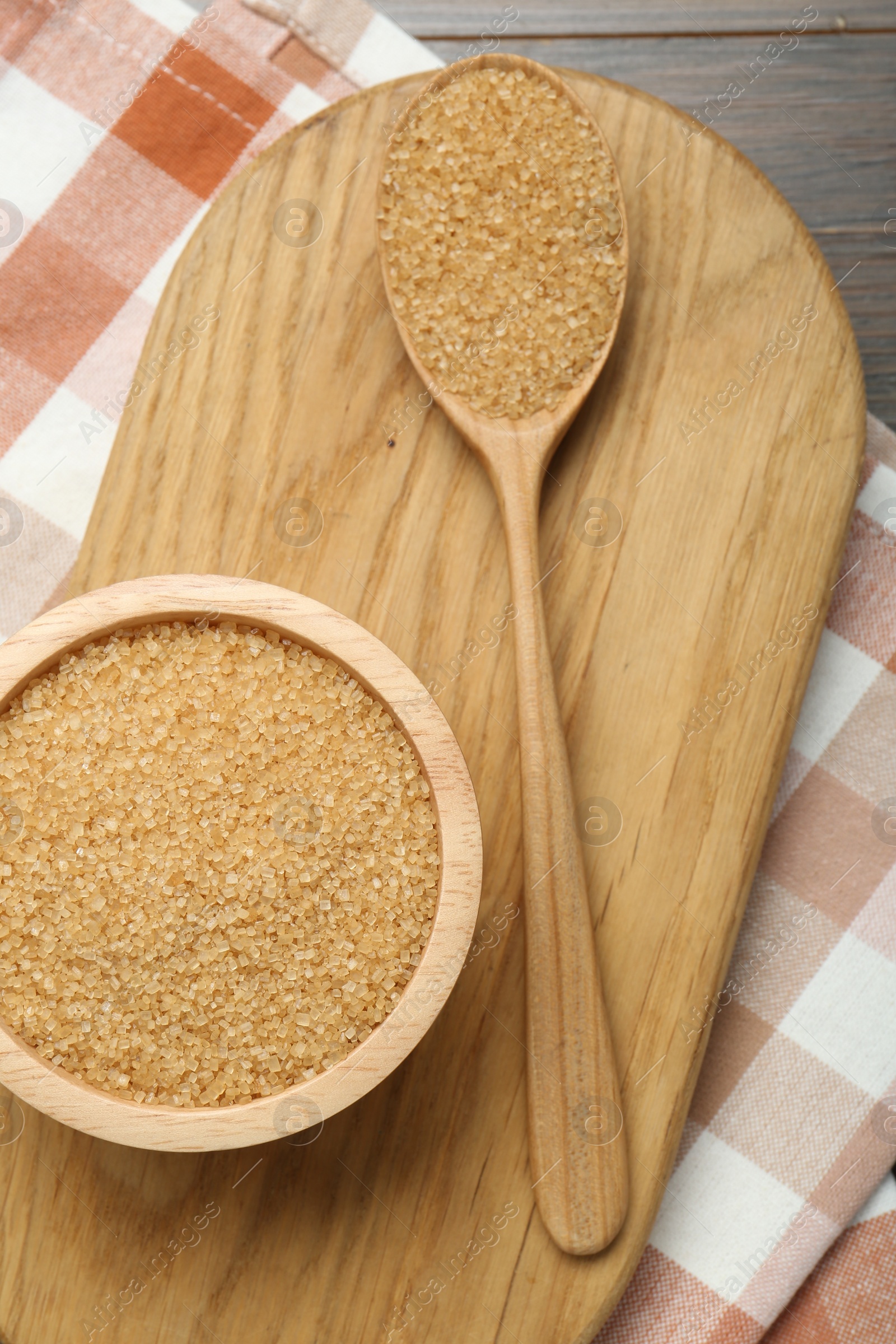 Photo of Brown sugar in bowl and spoon on table, top view