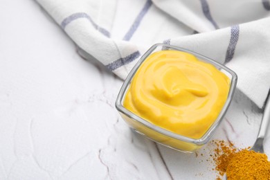 Photo of Tasty curry sauce and powder on white textured table. Space for text