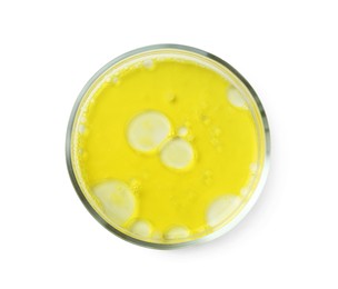 Petri dish with yellow liquid sample on white background, top view