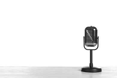 Photo of Retro microphone on table against white background. Space for text