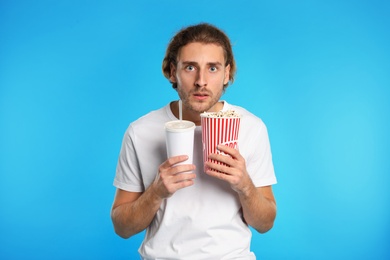 Photo of Emotional man with popcorn and beverage during cinema show on color background