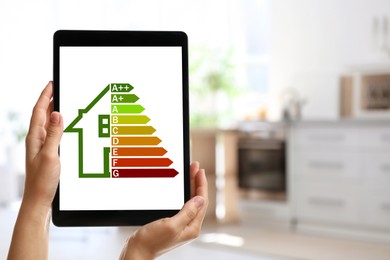 Image of Energy efficiency. Woman using tablet with colorful rating on display indoors, closeup