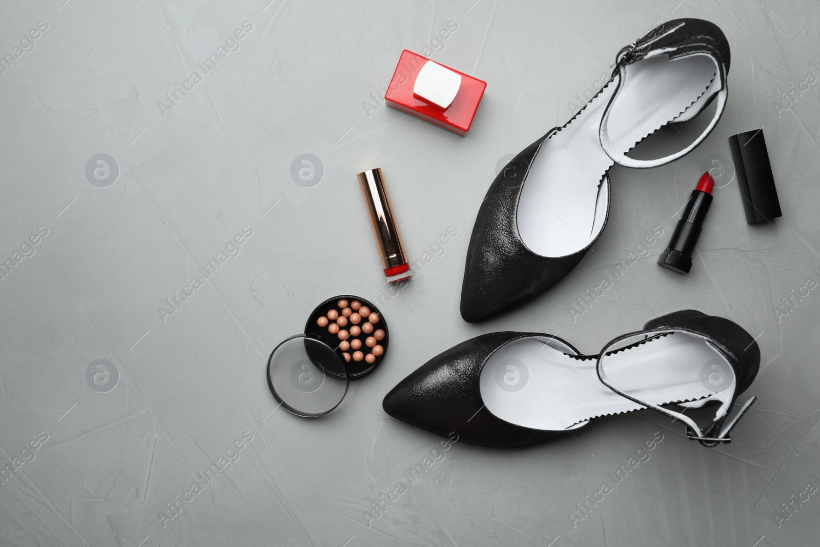 Photo of Flat lay composition with stylish shoes and cosmetics on grey table. Space for text
