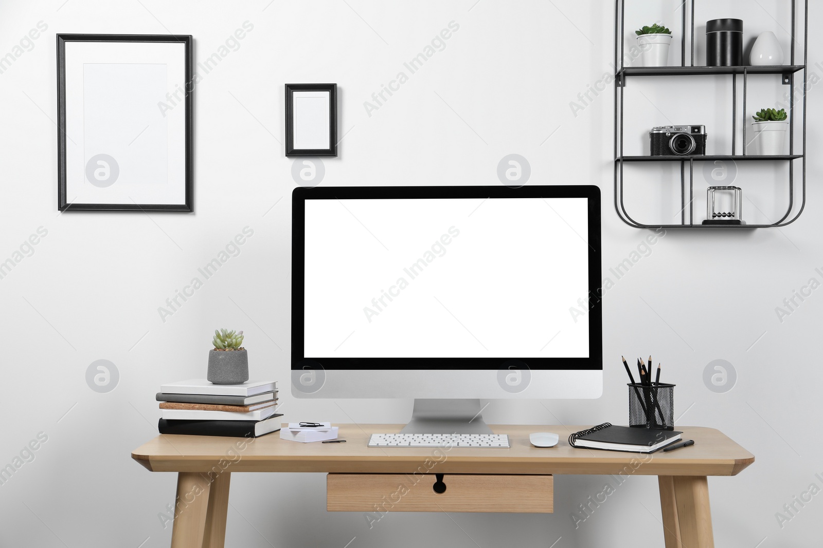 Photo of Cozy workspace with computer and stationery on wooden desk at home