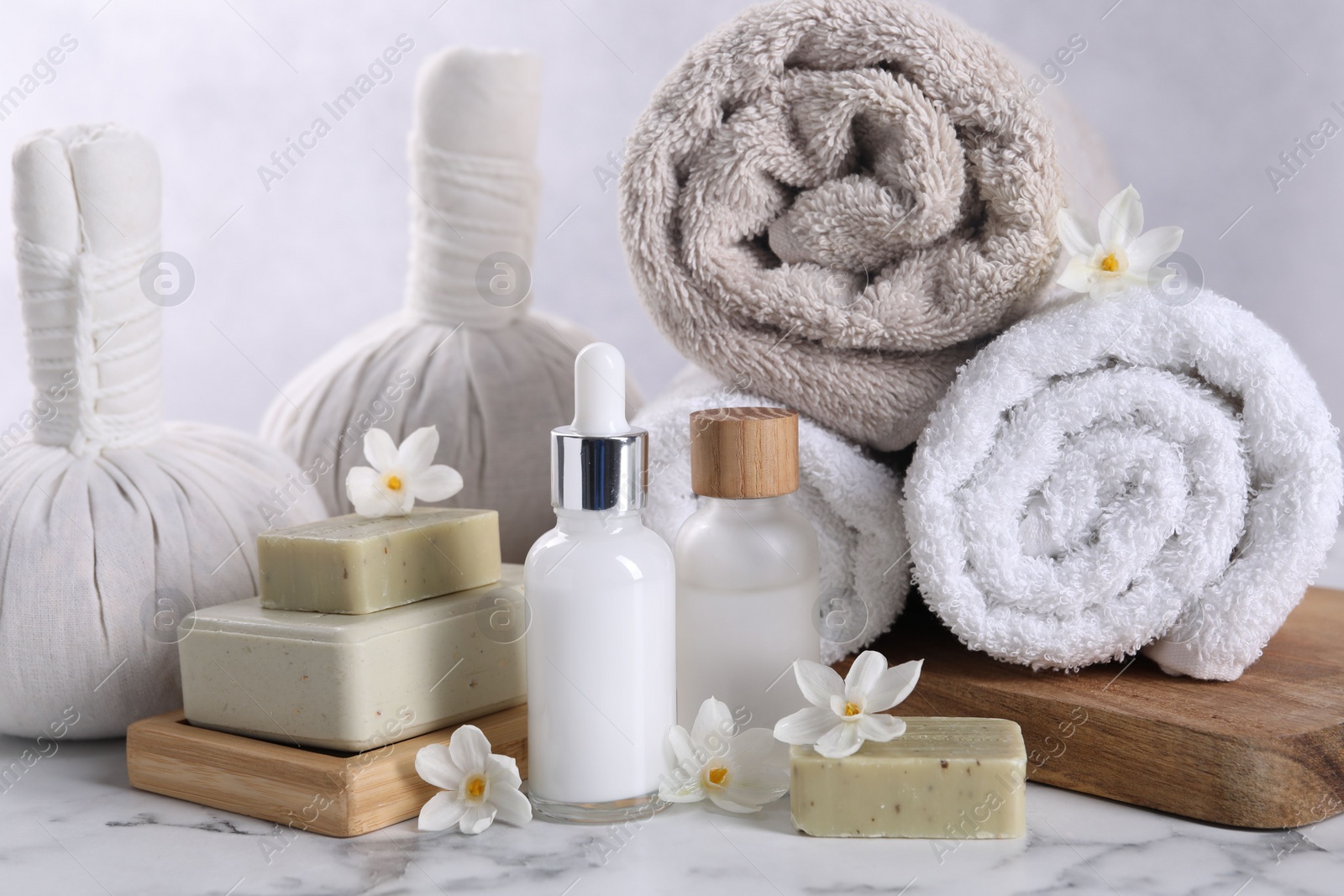 Photo of Composition with spa supplies and flowers on white marble table