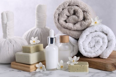 Composition with spa supplies and flowers on white marble table