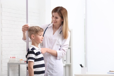 Doctor measuring little boy's height in hospital