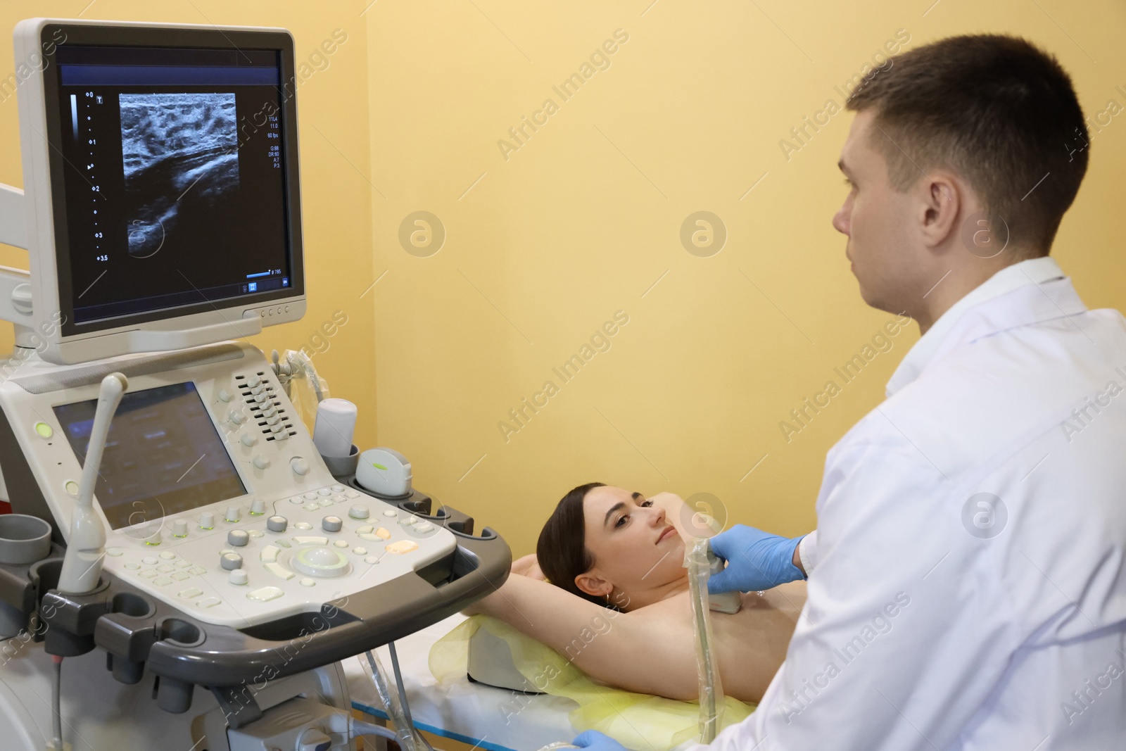 Photo of Mammologist conducting ultrasound examination of woman's breast in clinic