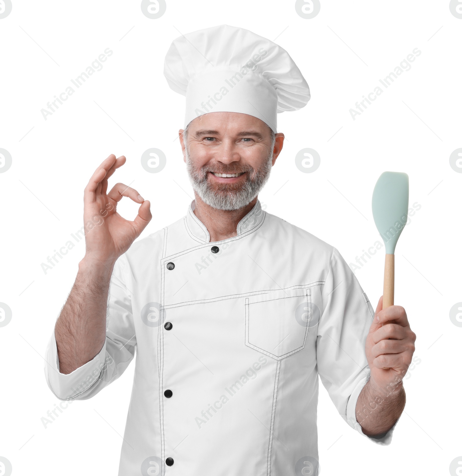 Photo of Happy chef in uniform with spatula showing OK gesture on white background