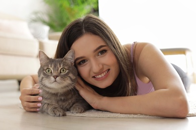 Young woman with cute cat at home. Pet and owner