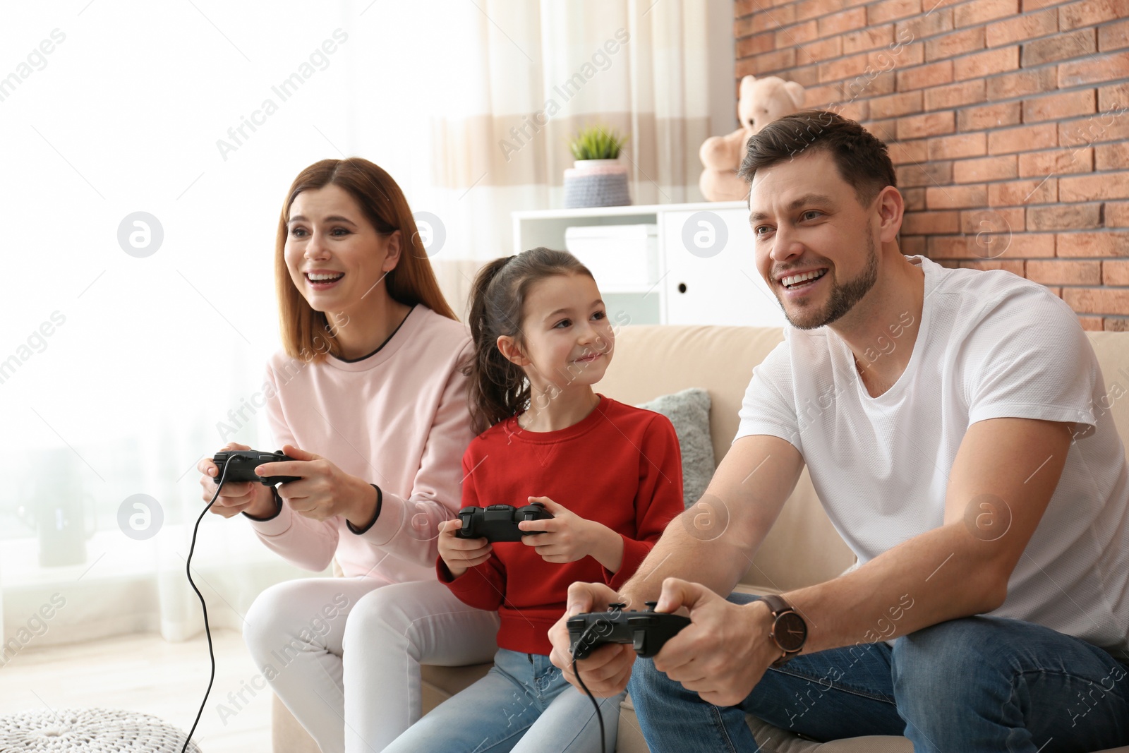 Photo of Happy family playing video games in living room