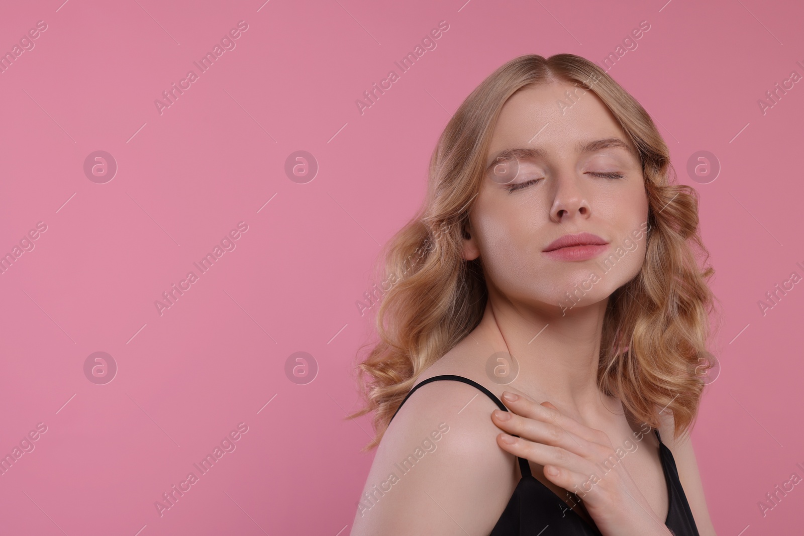 Photo of Portrait of beautiful woman with blonde hair on pink background. Space for text