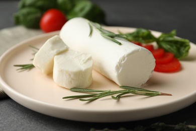 Photo of Delicious goat cheese with rosemary on plate, closeup