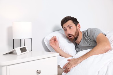 Photo of Emotional man in bed at home. Being late because of oversleeping