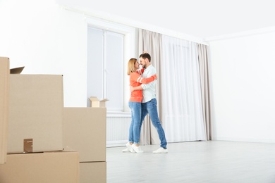 Happy couple dancing near moving boxes in their new house