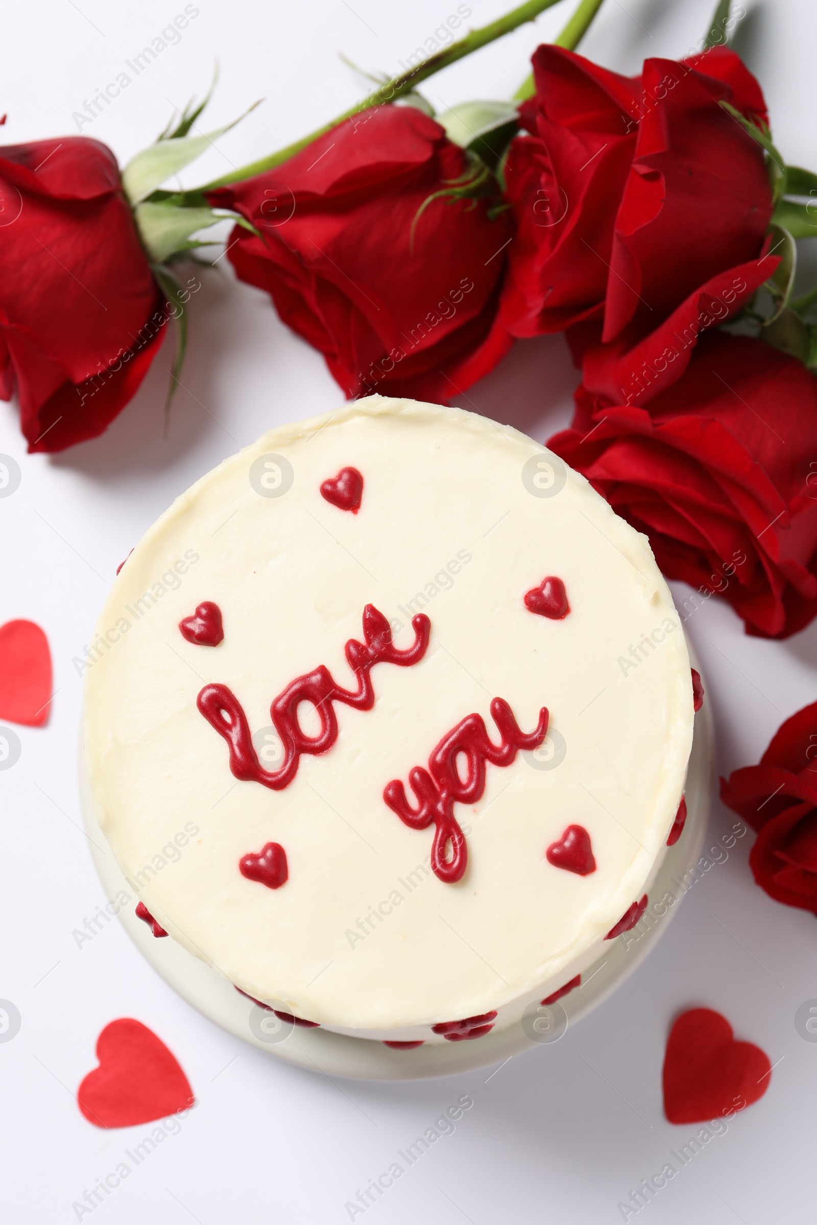 Photo of Bento cake with text Love You, paper hearts and roses on white table, flat lay. St. Valentine's day surprise