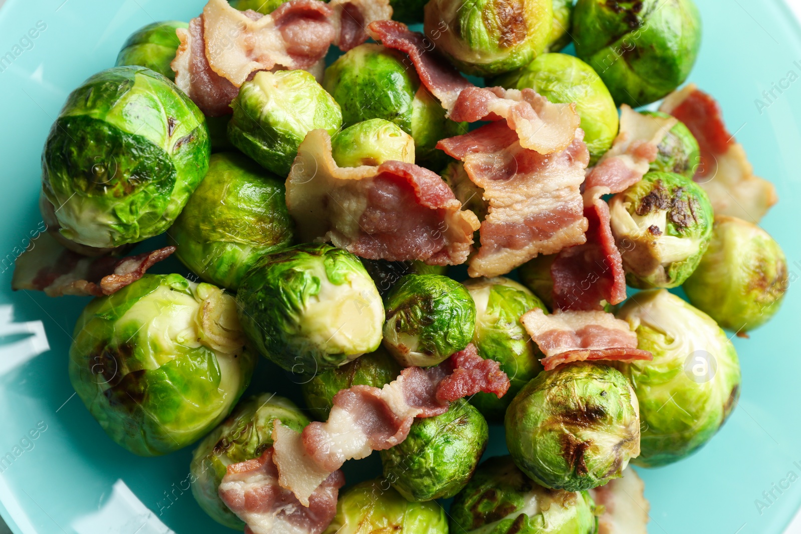 Photo of Delicious Brussels sprouts with bacon on plate, closeup