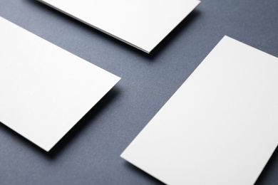 Photo of Blank business cards on dark grey background, closeup. Mock up for design