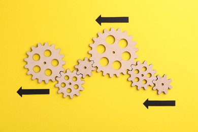 Business process organization and optimization. Scheme with wooden figures and arrows on yellow background, top view