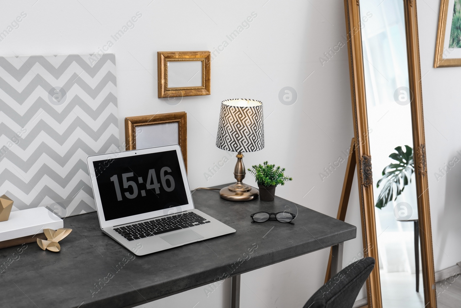 Photo of Stylish workplace with modern laptop on table indoors