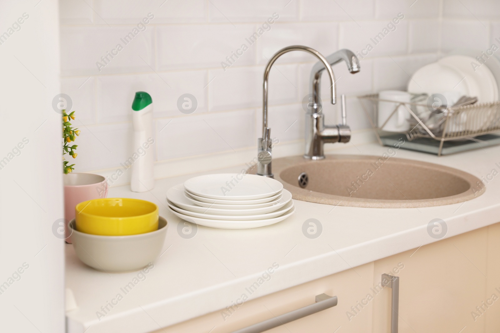 Photo of Clean dishes on counter near kitchen sink indoors