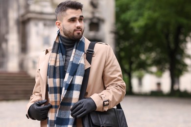 Handsome man in warm scarf on city street