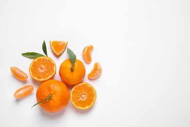 Photo of Composition with fresh ripe tangerines and leaves on white background, flat lay. Citrus fruit