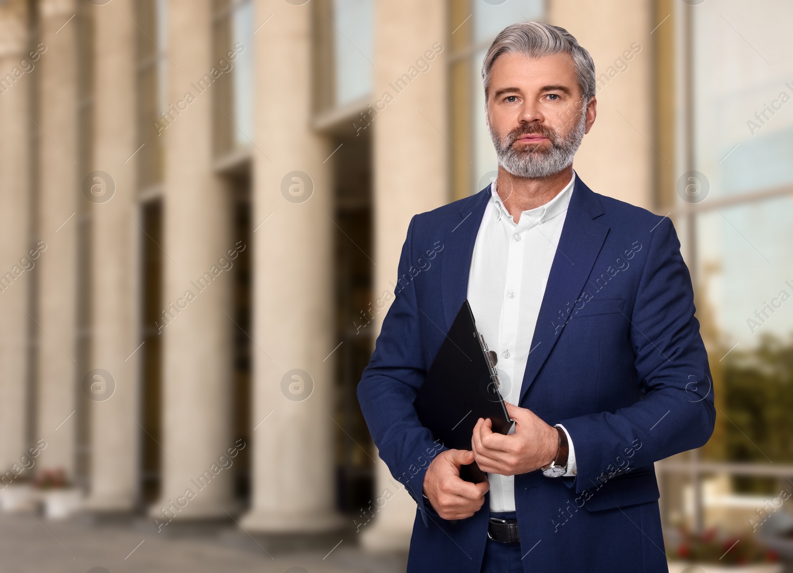 Image of Successful lawyer with clipboard near building outdoors, space for text