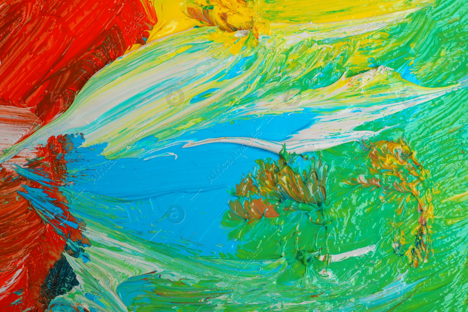 Photo of Closeup view of artist's palette with mixed bright paints as background