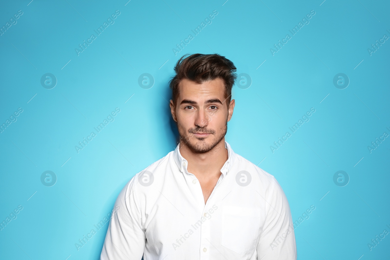 Photo of Young man with trendy hairstyle posing on color background