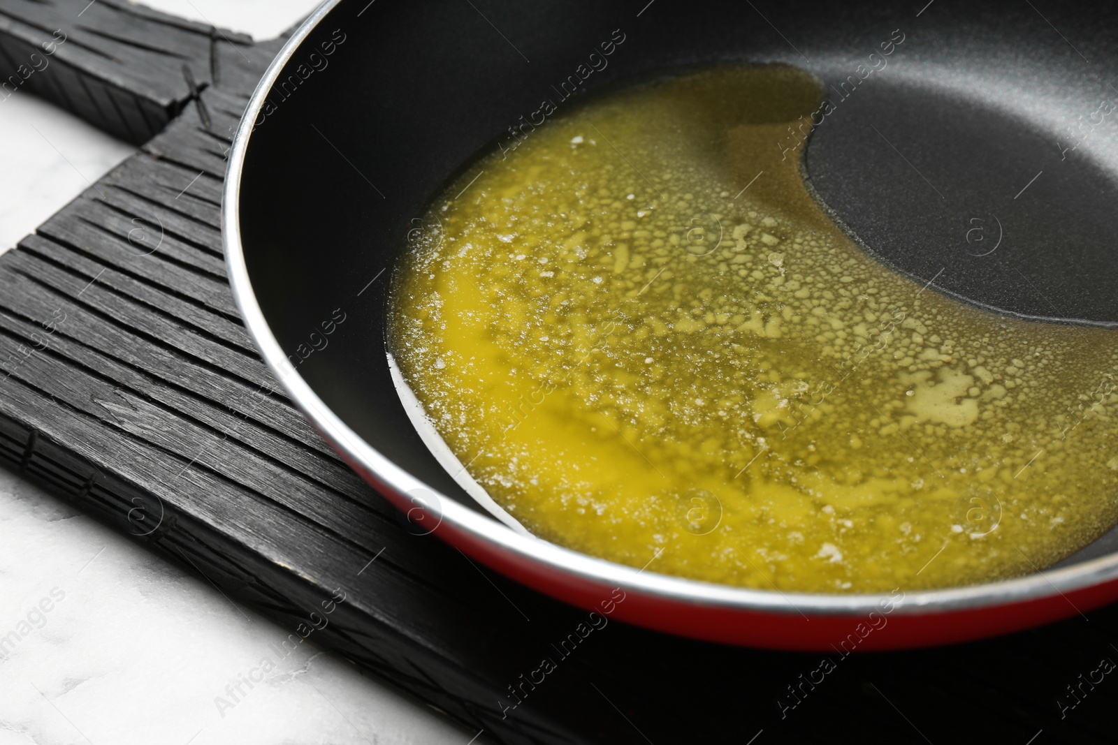 Photo of Frying pan with melting butter on table, closeup