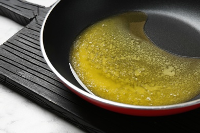 Frying pan with melting butter on table, closeup