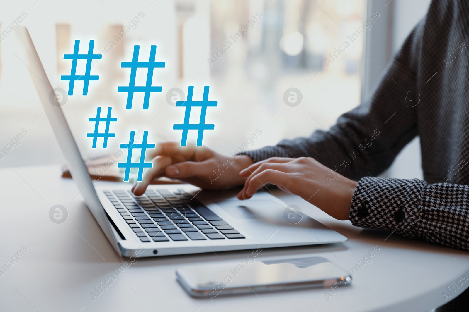 Image of Woman using modern laptop at table, closeup. Hashtag symbols over device