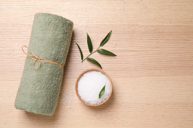 Photo of Flat lay composition with green towel on wooden table, space for text. Spa treatment