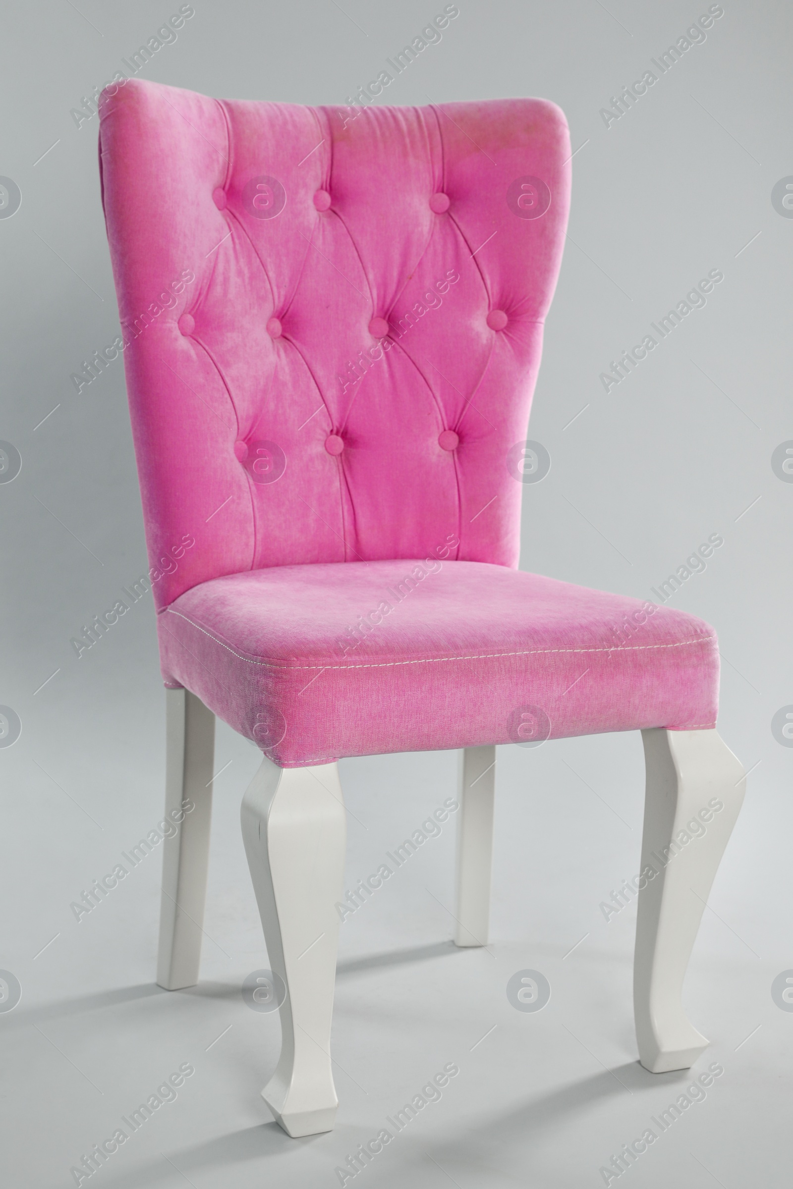 Photo of Stylish pink chair on light grey background. Element of interior design