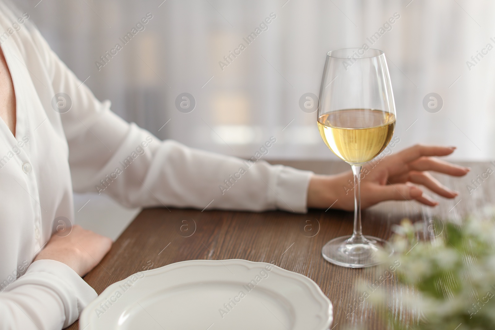 Photo of Woman with glass of wine at table in restaurant