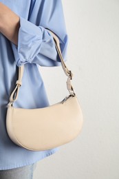 Photo of Woman with stylish baguette handbag on white background, closeup