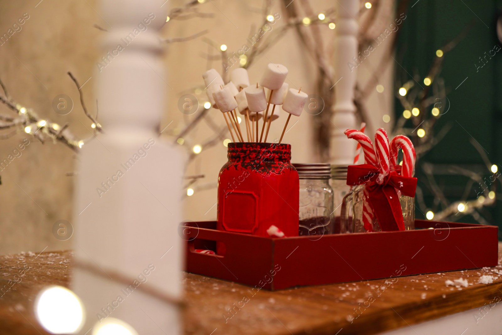 Photo of Marshmallow and candy canes in wooden tray. Christmas celebration
