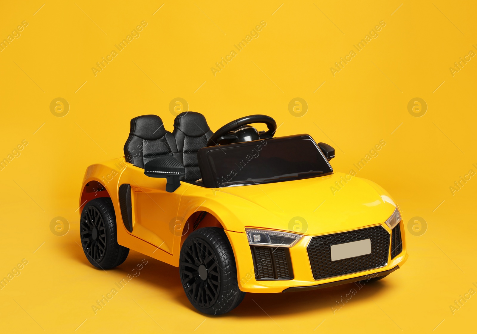 Photo of Children's electric toy car on yellow background