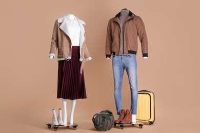 Photo of Female and male mannequins with accessories dressed in different clothes on beige background. Stylish outfits