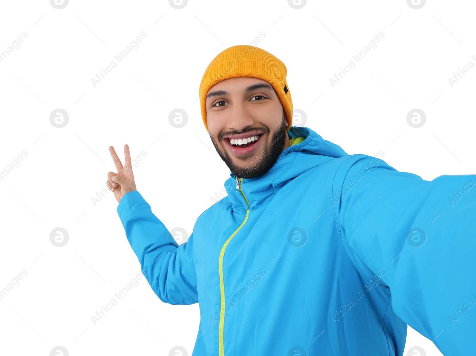 Photo of Smiling young man taking selfie and showing peace sign on white background