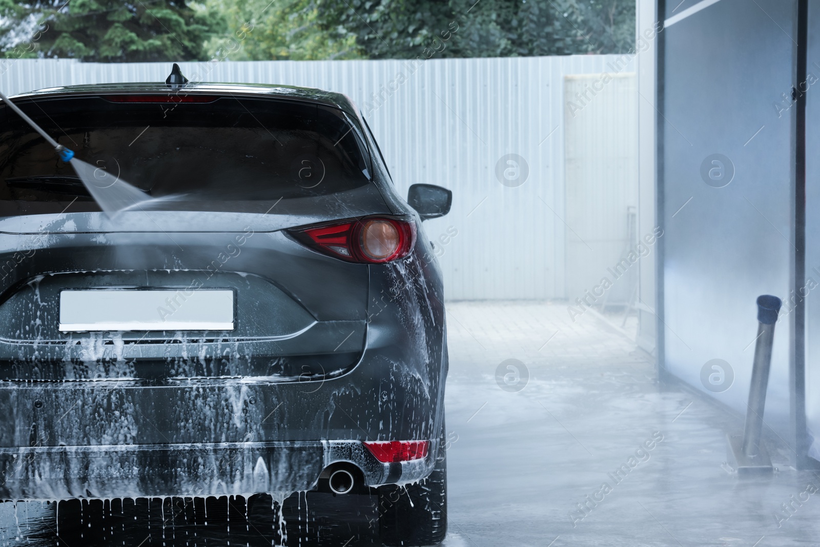 Photo of Washing auto with high pressure water jet at outdoor car wash