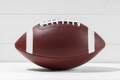 Photo of American football ball on white wooden background