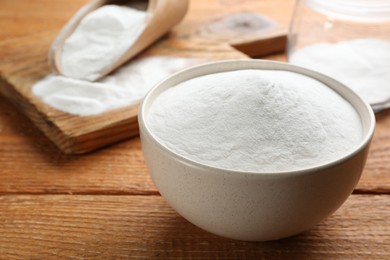 Photo of Baking soda on wooden table, closeup view