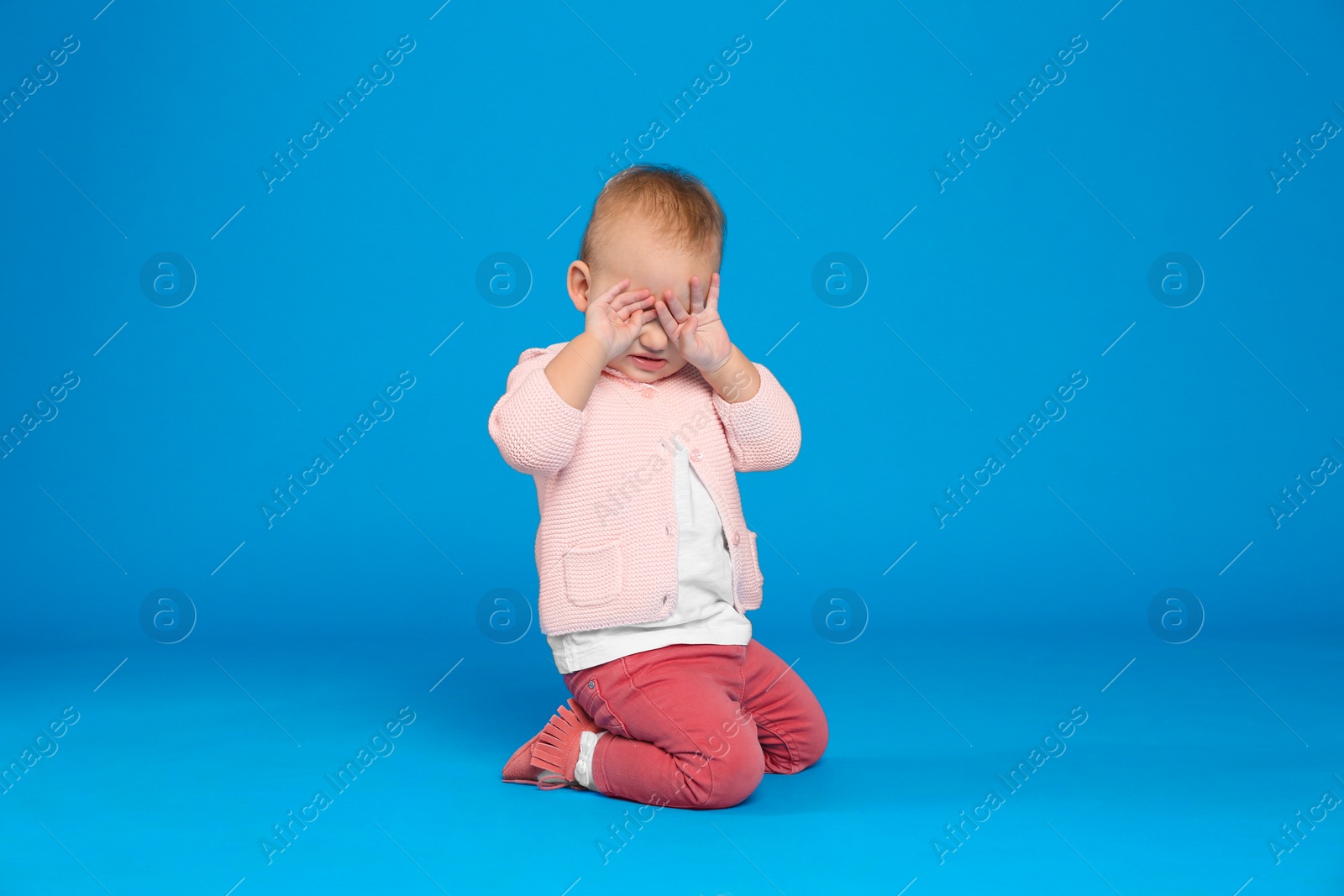 Photo of Cute little child on light blue background