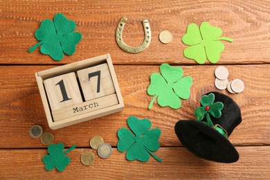 Leprechaun's hat, block calendar and St. Patrick's day decor on wooden background, flat lay