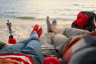 Photo of Couple resting near sea, closeup. Beach camping