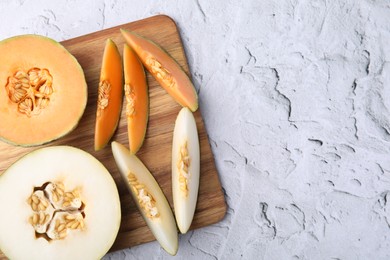 Photo of Tasty colorful ripe melons on white textured background, top view. Space for text