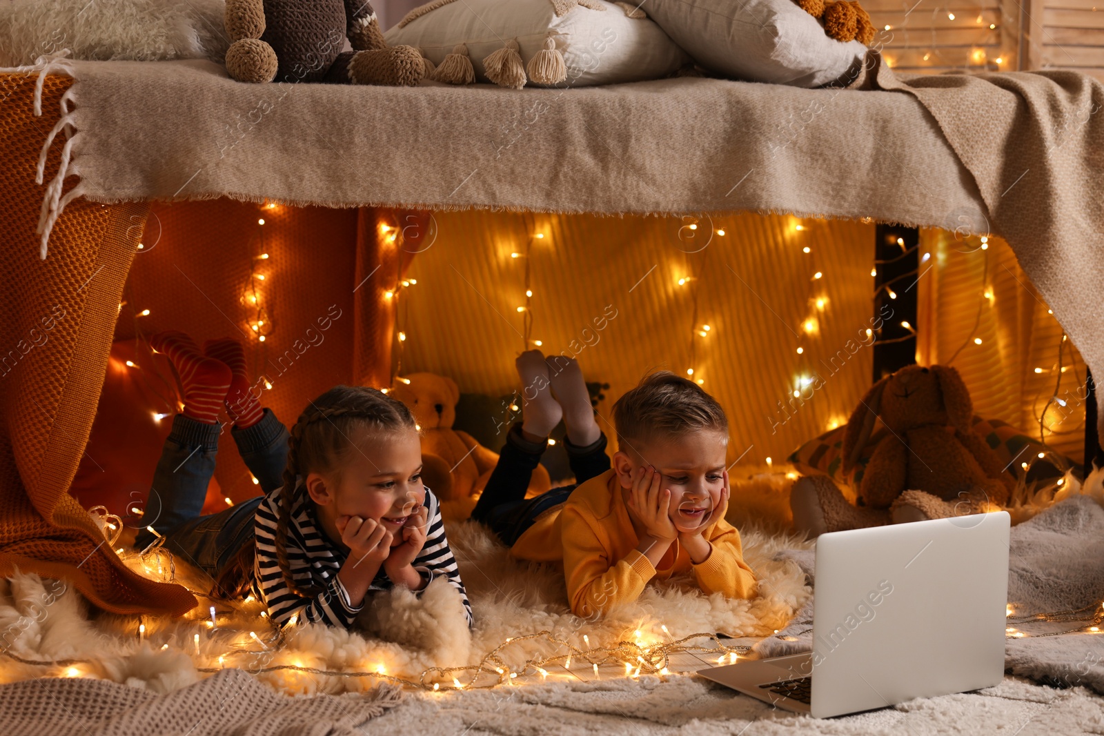 Photo of Kids with laptop in decorated play tent at home